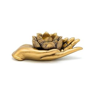 Kullanvärinen Käsi pitelee herkästi Kultaista Lotus -tuikkukuppia